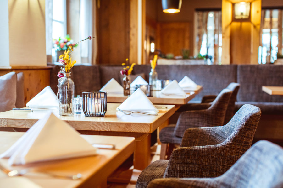 Ein paar schön gedeckte Holztische im Wirtshaus in Nürnberg, mit grauen Stoffstühlen in einem gemütlichen Ambiente.