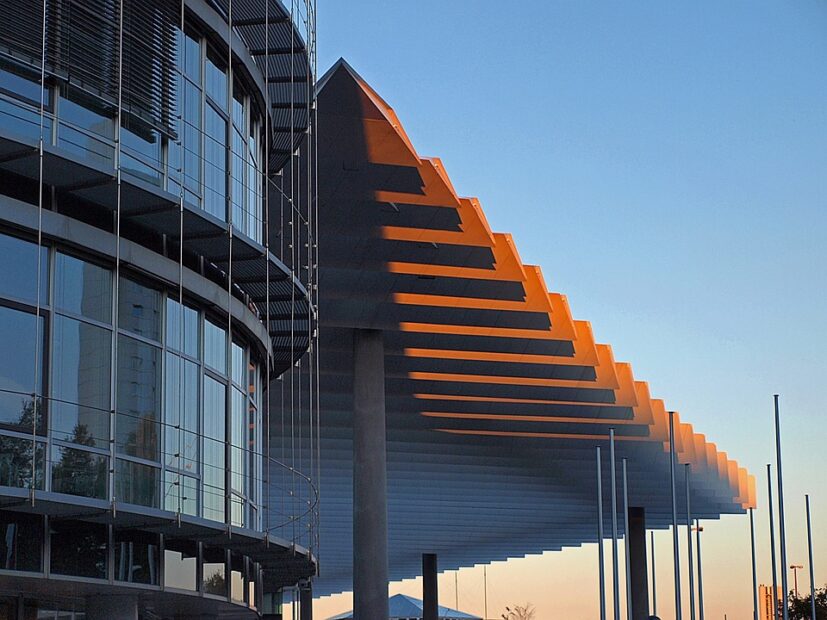 Das gläßerne Messegebäude, daneben ein modernes Dach auf Säulen am Messehotel in Nürnberg